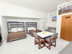 A compact hotel room with two beds, a dining table, and a small kitchenette. - Cathedral Centro Histórico D14 (Guadalajara)