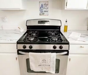 A kitchen with a stove, oven, and a sign above the stove. - 3B/2Ba House 5 minutes from The Domain (Austin)