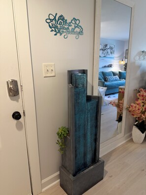 A hallway with a decorative wall piece, a door with a lock, and a plant. - Brand New in October! 2 Bikes to Ride to Beach/Coligny/Pool/Tennis (Hilton Head Island)