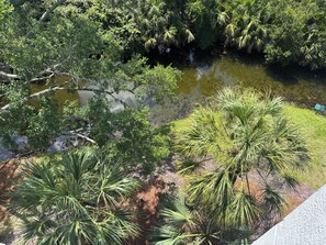 A natural landscape with a water body, dense greenery, and a paved path. - Brand New in October! 2 Bikes to Ride to Beach/Coligny/Pool/Tennis (Hilton Head Island)