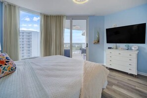 A hotel room with a bed, a television, a dresser, and a balcony with a view of the city. - Pool Views,  2 Bed 2 Bath,Balcony, Lagoon Pool,Shuttle,The Palms of Destin (Destin)