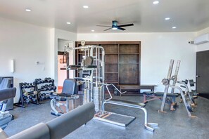 A gym with various exercise equipment, including a squat rack, bench press, and dumbbells. - Ocean View Condo -  Pools, Beach Access & More (Playas de Rosarito)