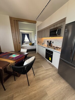 Une cuisine moderne équipée d’un four à micro-ondes, d’une cuisinière et d’un réfrigérateur intégrés.