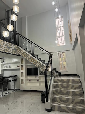 A modern interior with a staircase, a kitchen area, and a dining space.