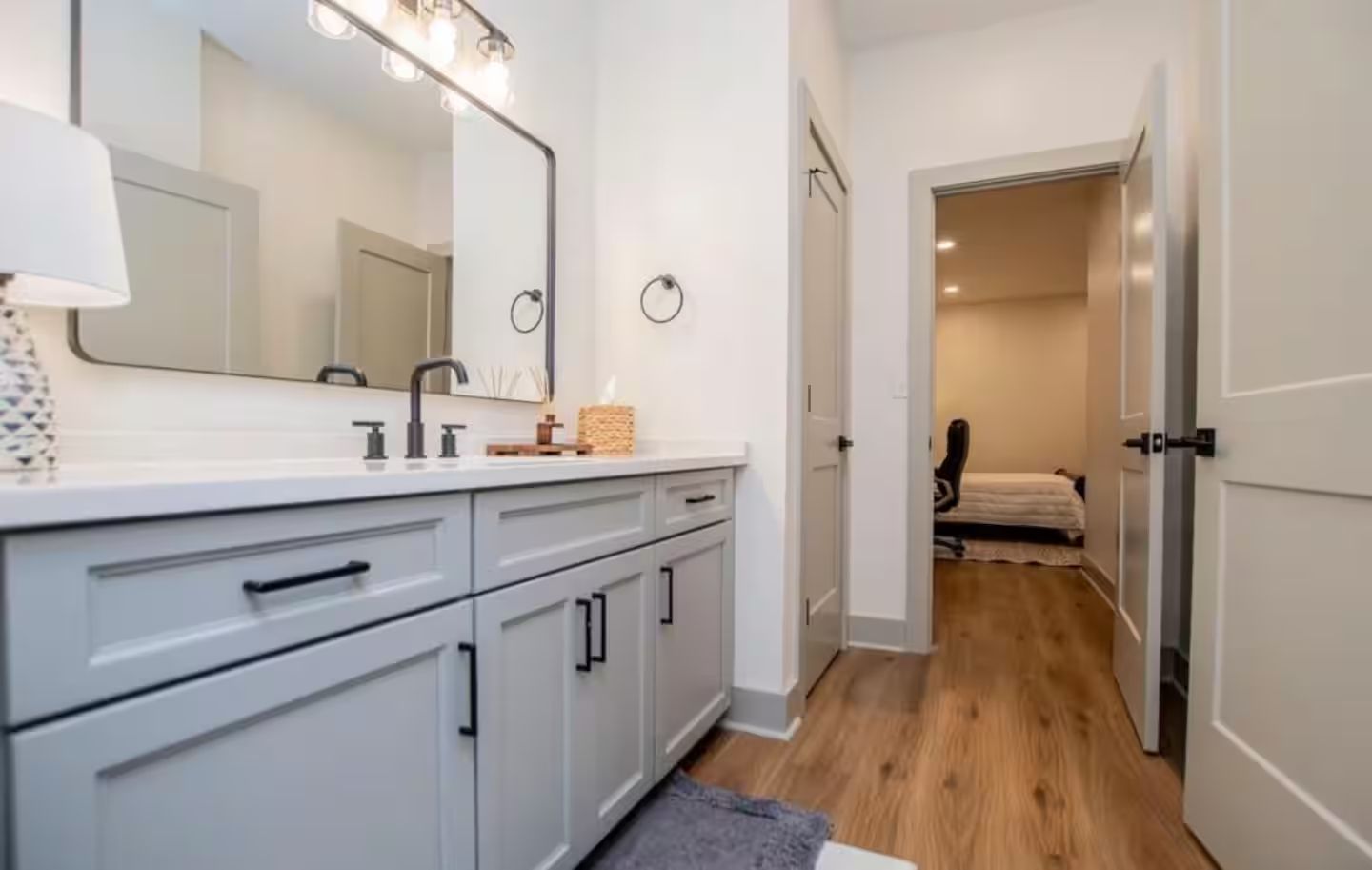 A modern bathroom with a vanity, mirror, and lighting.