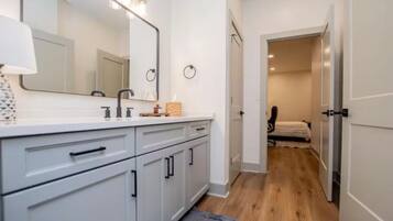 A modern bathroom with a vanity, mirror, and lighting.