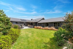 A modern two-story house with a well-maintained lawn and a variety of shrubs. - Loch View - Kinloch, Taupo *spa pool* (Kinloch)