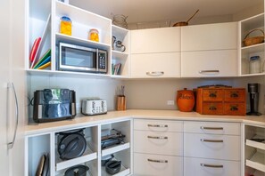 A kitchen with white cabinetry, a microwave, a toaster, and a coffee maker. - Loch View - Kinloch, Taupo *spa pool* (Kinloch)