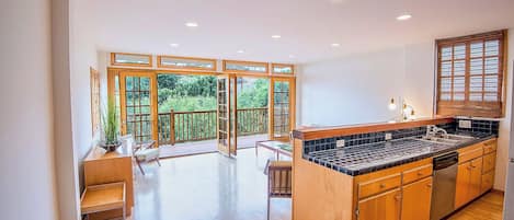 A spacious kitchen with wooden cabinets, a black countertop, and a built-in dishwasher.