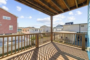 Eine Holzterrasse mit Geländer mit Blick auf ein Wohngebiet und mehrere Häuser.