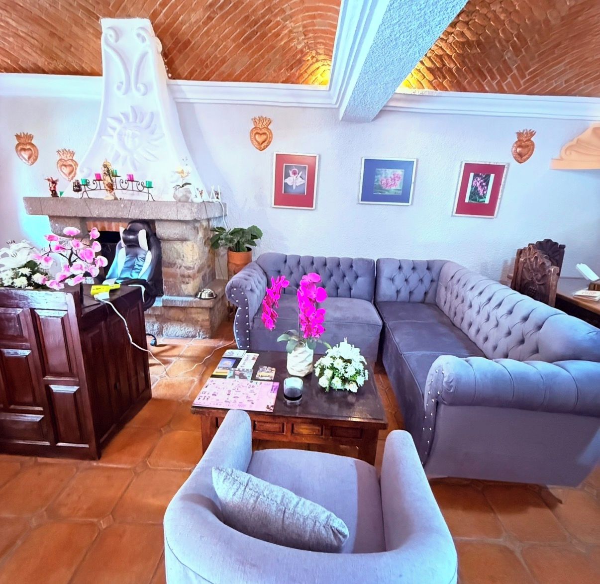 A living room with a grey sofa, a wooden coffee table, and a stone fireplace.
