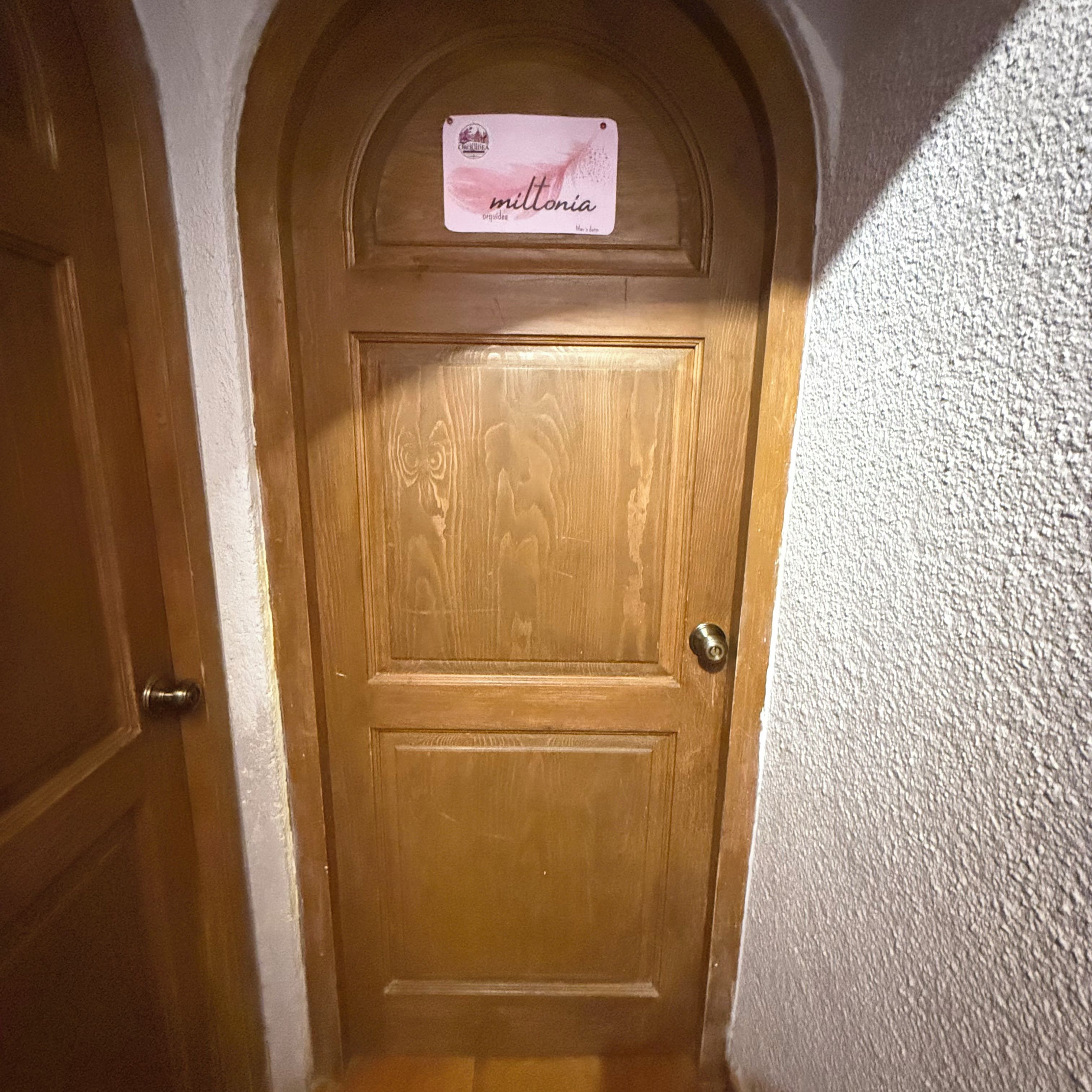 Una puerta de madera con un letrero encima.