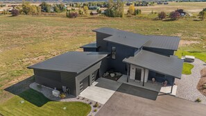 Une maison moderne à deux étages, dotée d’un grand garage, d’un patio couvert et d’une pelouse bien entretenue.