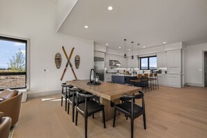 A modern kitchen with a central island, bar stools, and pendant lighting. - New Luxury 4 bed | Hot Tub w/ Teton View | Targhee | AC (Driggs)
