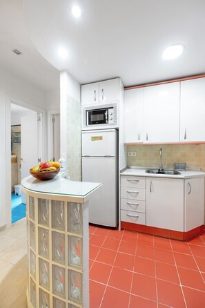 A kitchen with white cabinets, a microwave, a refrigerator, and a sink. - Encanto Nazarí · Your Little Corner in Granada (Granada)
