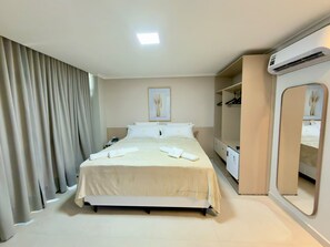 A hotel room with a bed, a bedside table, a mirror, an air conditioning unit, and a wardrobe. - HOTEL IRMAOS SANTANA LTDA (Santarém)
