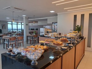A modern breakfast buffet with various food items and a coffee station.