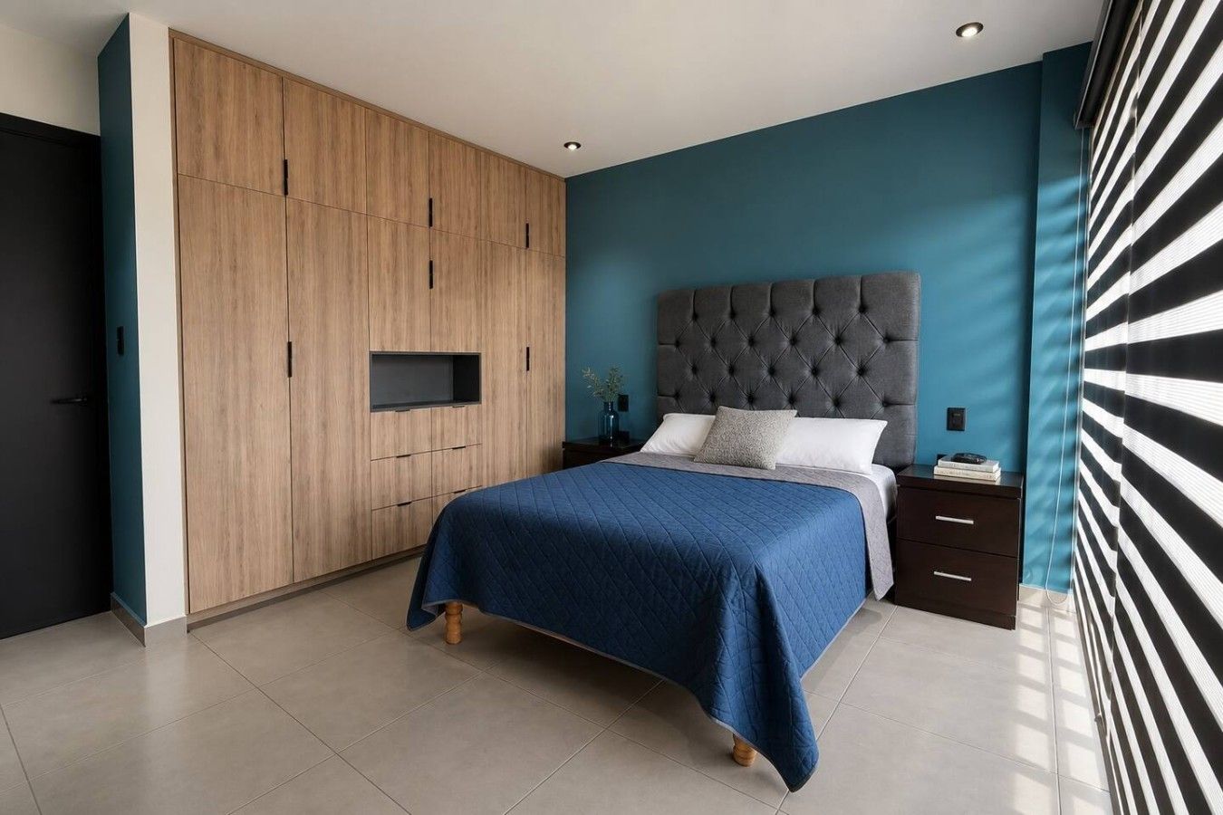 Ein Schlafzimmer mit einem Bett, einem Nachttisch, einer Kommode und einer eingebauten TV-Konsole.