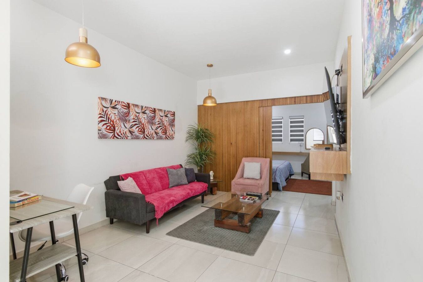 Un salon moderne comprenant un canapé, un fauteuil, une table basse et un coin repas avec une table et des chaises.