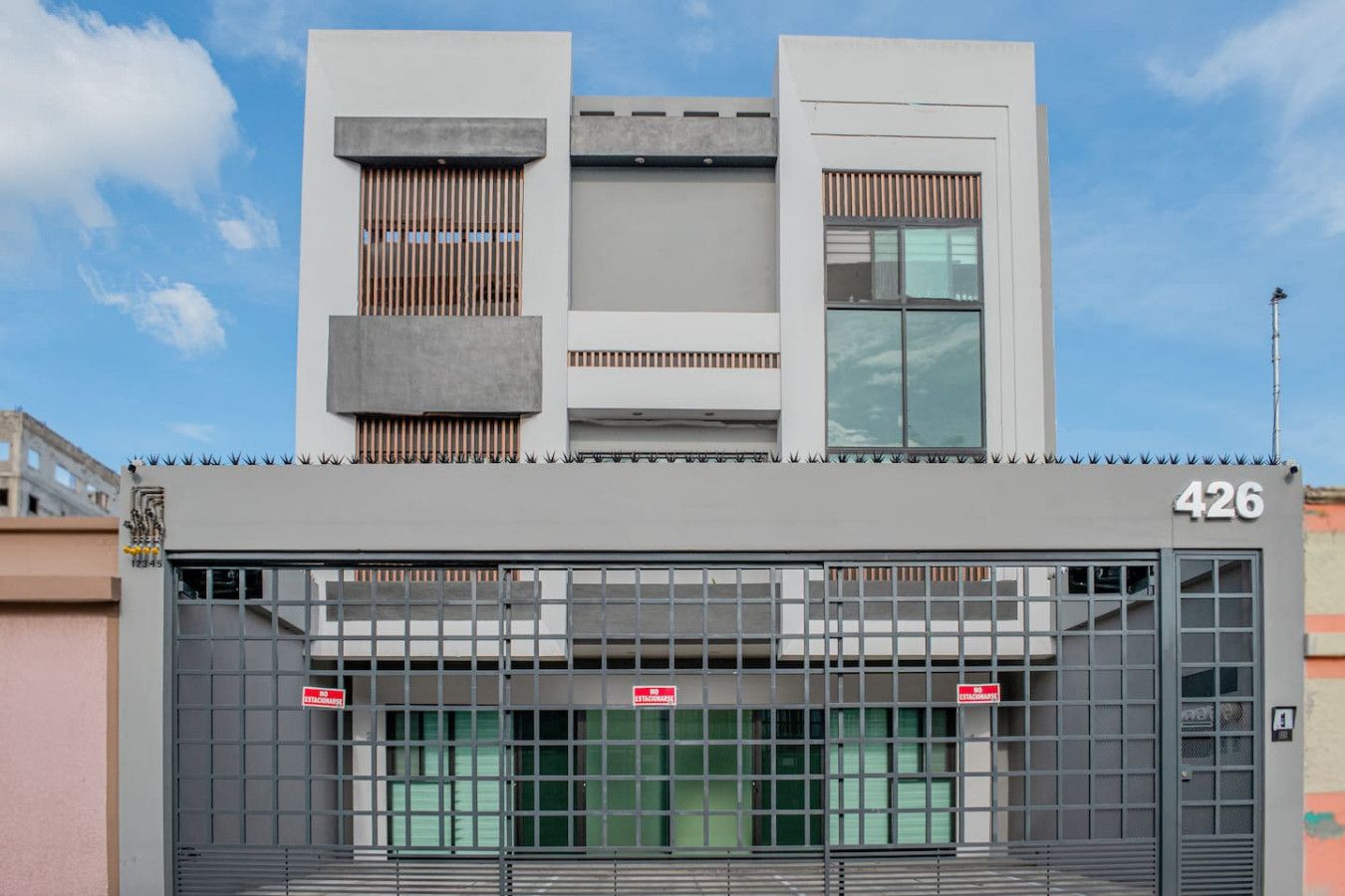 A modern building with a gated entrance, numbered 426.