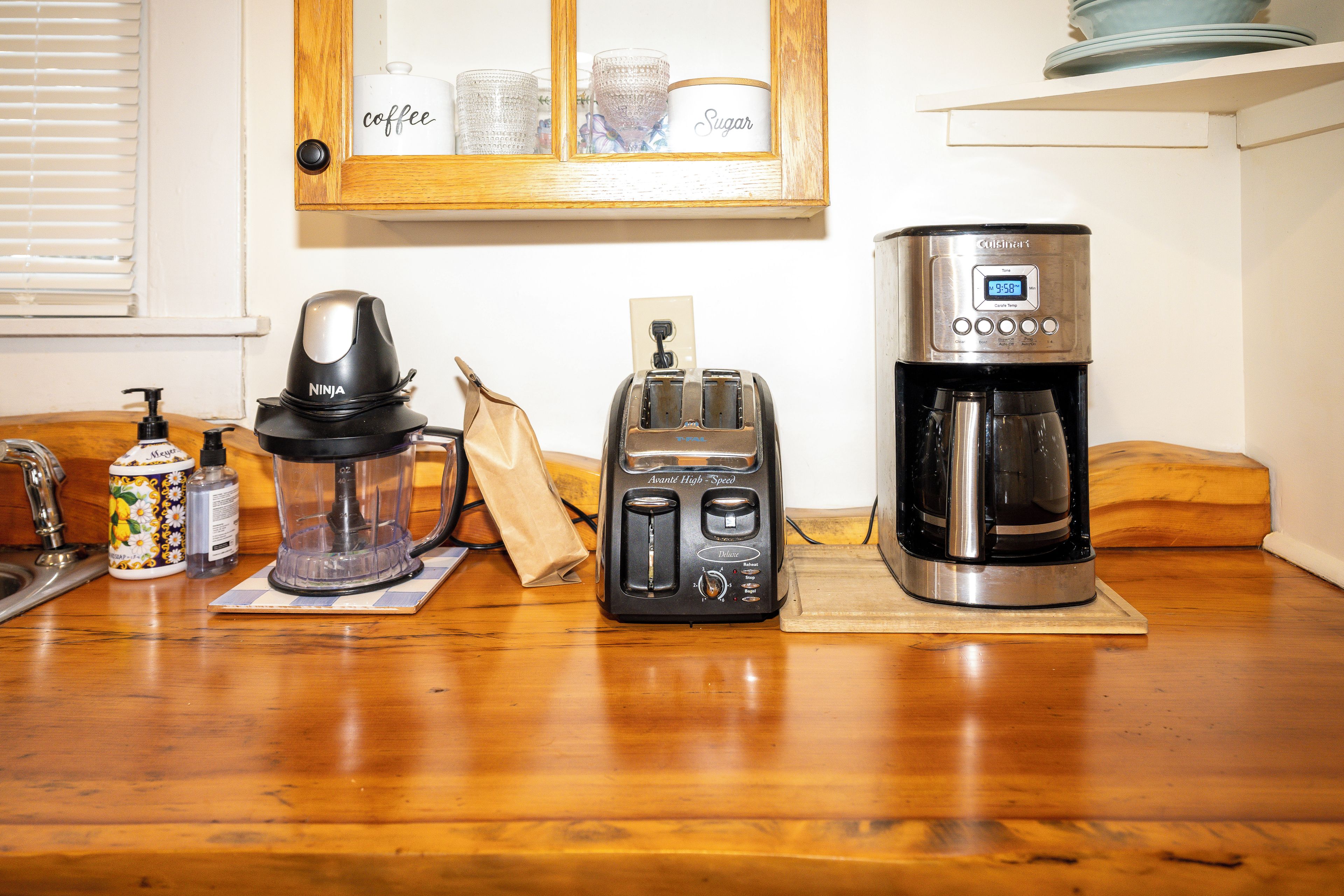 A kitchen counter with a coffee maker, toaster, and blender.