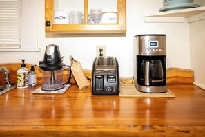 Eine Küchenarbeitsplatte mit Kaffeemaschine, Toaster und Mixer.