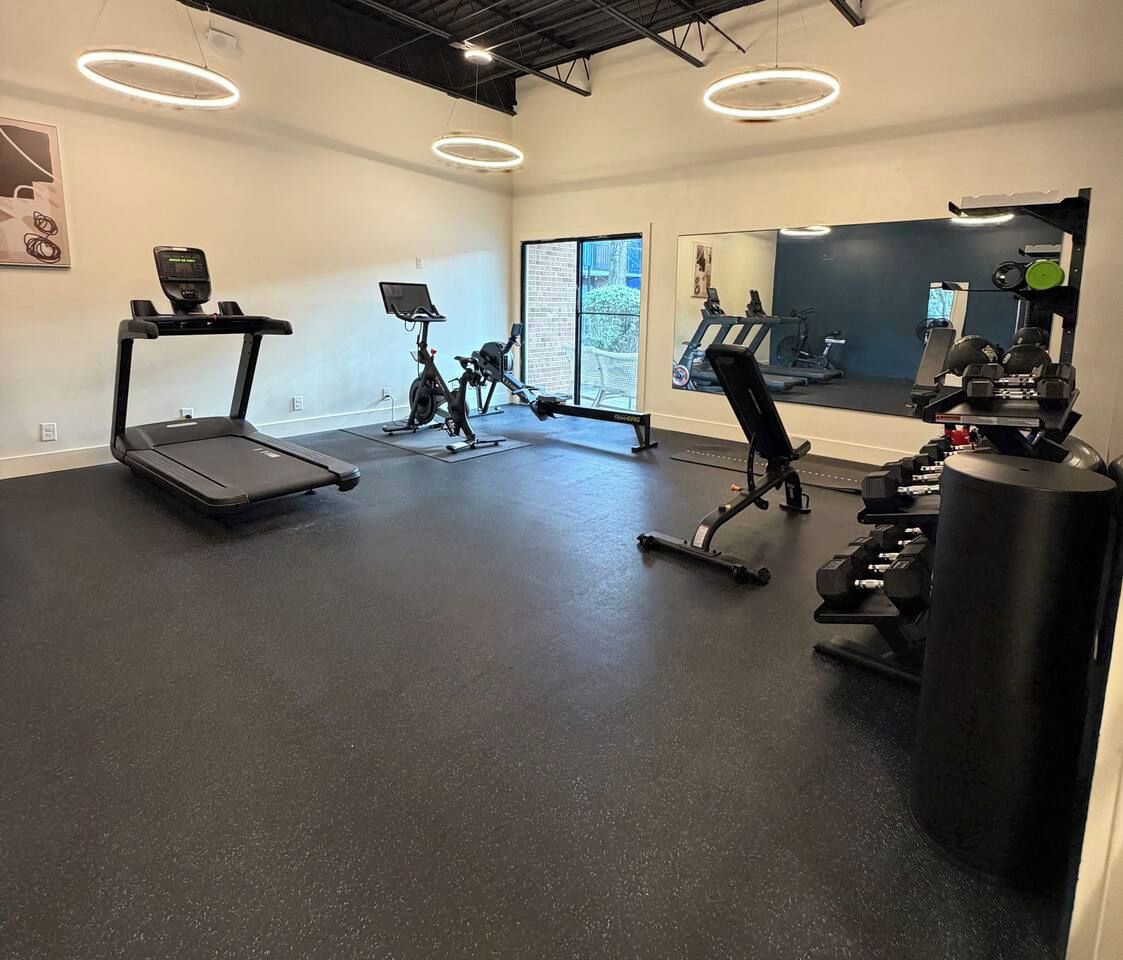 A gym with treadmills, stationary bikes, and weightlifting equipment.