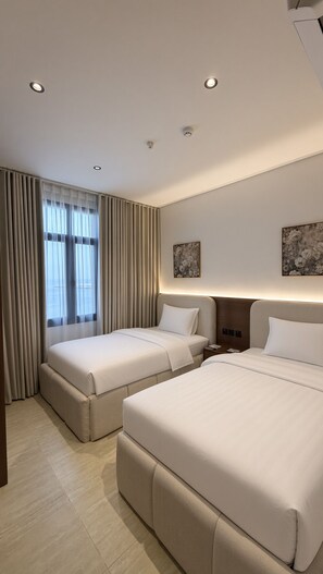 A hotel room with two beds, a large window with curtains, and a ceiling with recessed lighting. - Luxury Apartment 3BR With Sea View (Al Khobar)