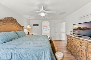 A bedroom with a large bed, a ceiling fan, a television, and a wooden dresser. - 5BR Splash House in Davenport | Pool & Game Room (Davenport)