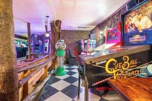 A pinball machine with a checkered floor and wooden elements. - Cozy Lakeview Retreat with Patio & Firepit (Rockaway Beach)