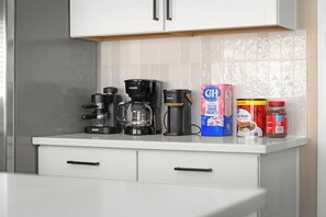 A kitchen counter with a coffee maker, a box of sugar packets, and a jar of peanut butter. - Pool & Hot tub • Arcades • Air Hockey • Foosball • Mini-Golf (Las Vegas)