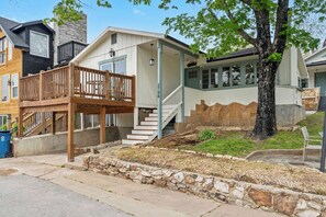 A residential property with a two-story structure, a wooden deck, and a stone retaining wall. - The Ravens Roost Lakeview Retreat-Walk to the Park/Fishing/Boating (Rockaway Beach)