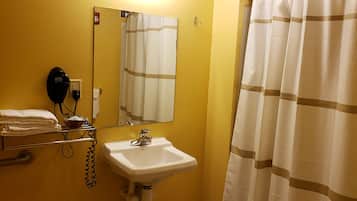 A bathroom with a sink, a hairdryer, and a towel rack.