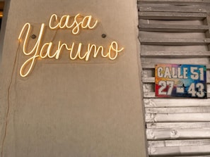 A neon sign reading 'casa Yarum' and a colorful street sign with 'CALLE 51 27-43'. - Casa Yarumo (Neiva)