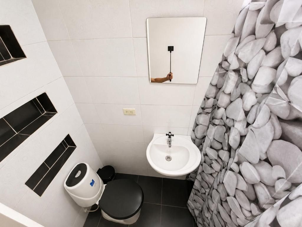 Un baño pequeño con inodoro, bidé y lavamanos.