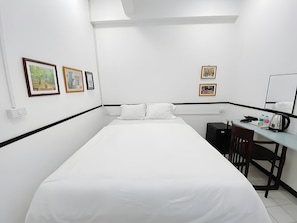 A hotel room with a bed, a desk, and two framed pictures on the wall. - B room Hualumphong (Bangkok)