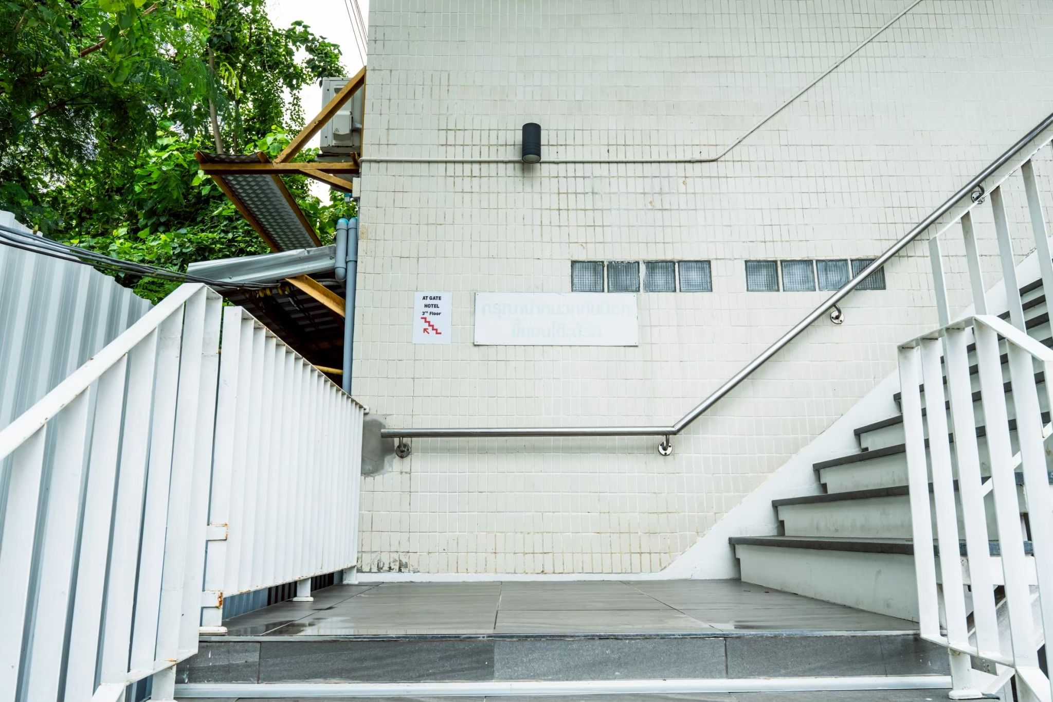 A staircase leading to a hotel entrance with a sign indicating the location on the 3rd floor.