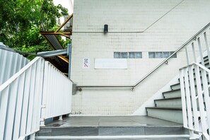 Una escalera conduce a la entrada de un hotel, con un letrero que indica la ubicación en el tercer piso.
