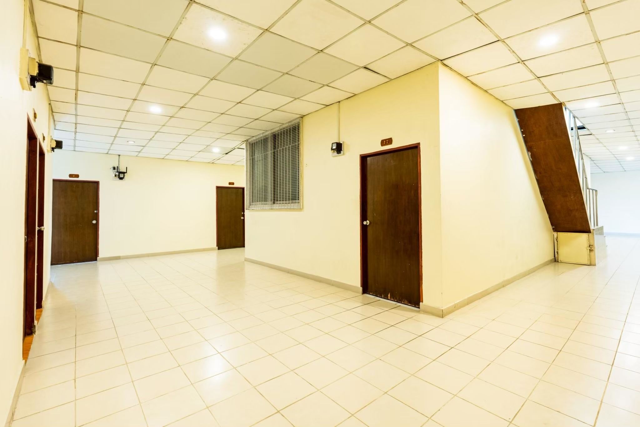 Un hall d’entrée spacieux, doté d’un sol carrelé, de plusieurs portes et d’un escalier menant à l’étage supérieur.