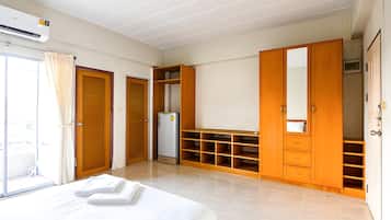 A hotel room with a bed, wardrobe, and a mirror.