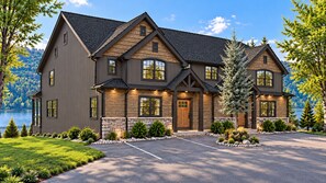 Une maison à deux étages, avec des fondations en pierre, de grandes fenêtres et une allée menant à un espace de stationnement.