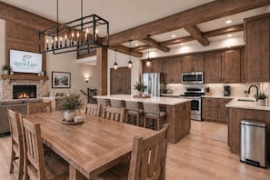 A modern kitchen with wooden cabinets, a central island, and a fireplace. - Boat Lover's Escape! Lakefront Lodge + Slip, Pool, Pickleball, Golf (Hollister)