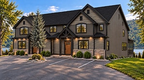 A two-story house with a stone foundation, multiple windows, and a driveway leading to a parking area. - Golf Trip Ready! 4 Kings | Lakefront Lodge | Minutes to Golf Courses (Hollister)