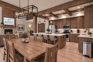 A modern kitchen with wooden cabinets, a central island, and a fireplace. - Lakefront Lodge | River Views & Resort Fun | Pool, Golf & Dock (Hollister)