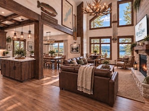 A spacious living area with a fireplace, large windows, and a view of the outdoors. - Luxury Villa on Lake Taneycomo | 4 King En Suites | Private Dock and Putting Course (Hollister)