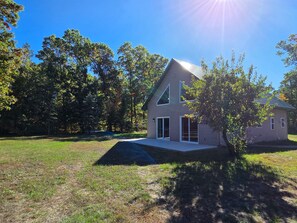 A single-story house with a sloped roof, a front porch, and a visible garage door. - Cozy 2-bedroom house in charming Danbury, WI on the Gandy Dancer Trail (Danbury)