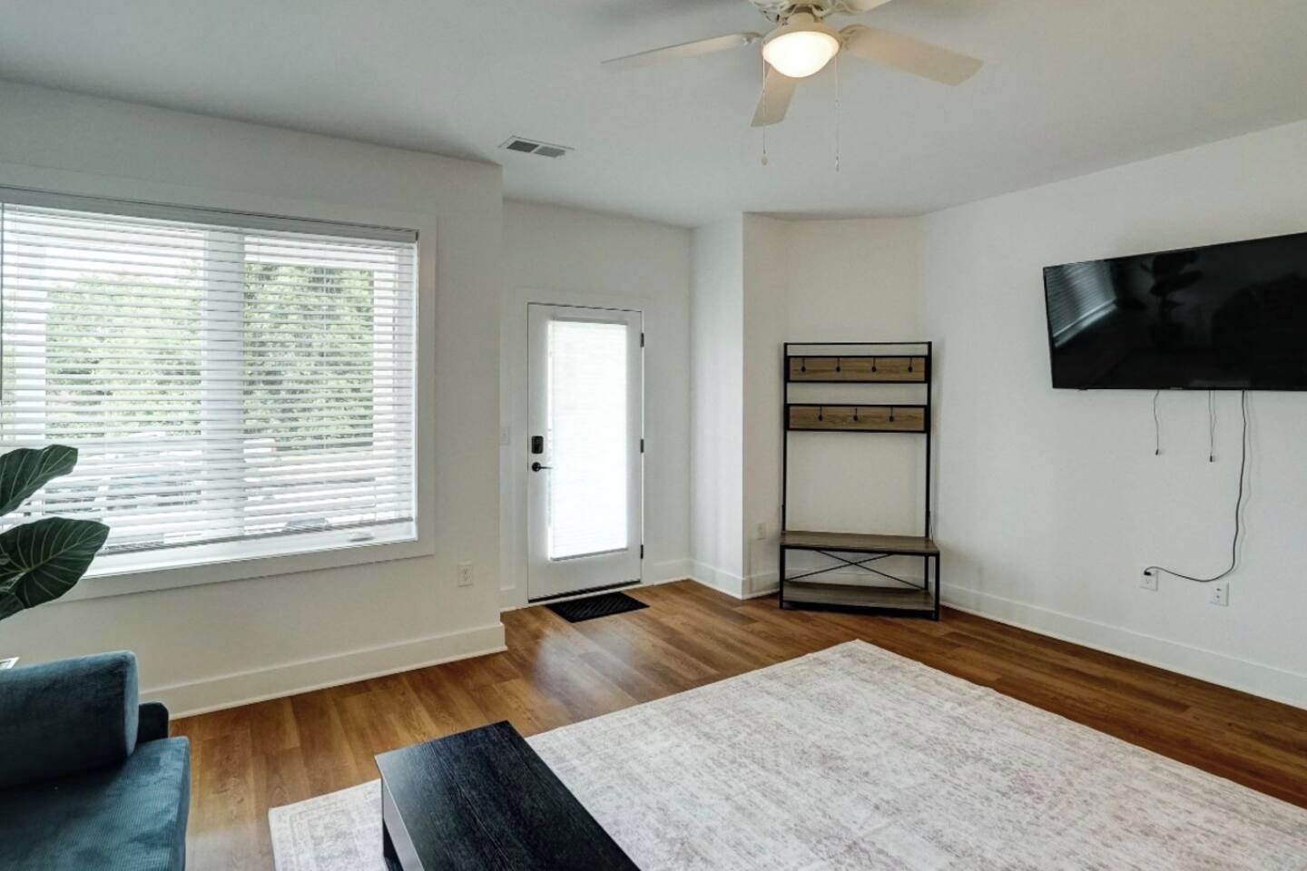 Bright living room with big windows, TV, and warm wood floors