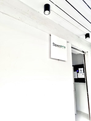 A sign labeled 'SleepPop' on a white wall, indicating a room or area within a building. - L room Sukhumvit 42 (Bangkok)