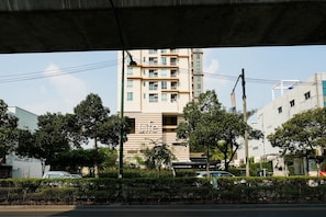 A multi-story building with a 'Life' sign, surrounded by trees and parked cars. - L room Sukhumvit 42 (Bangkok)