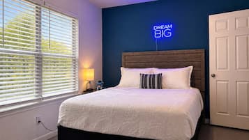 Ein Schlafzimmer mit einem Bett, einer Neonreklame, einem Nachttisch und einer Tür.
